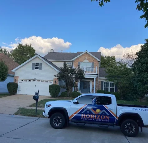 Damaged shingles on a St. Charles roof after a storm
